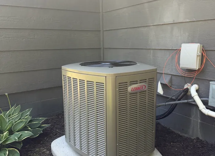 A Lennox central air conditioning condenser installed beside a Bloomington home